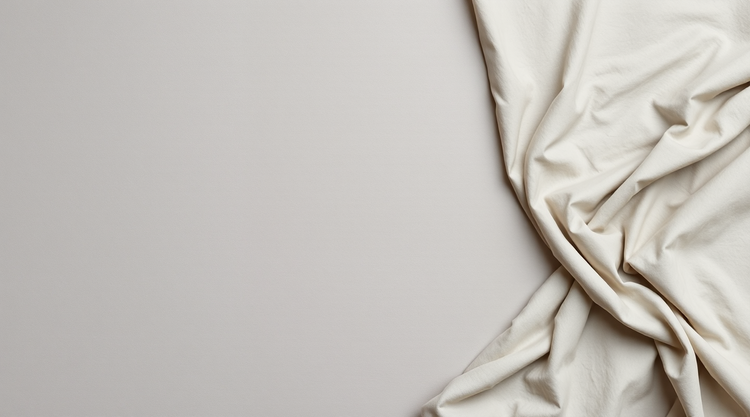 Soft stone-grey fabric with fine folds gathered at the right edge